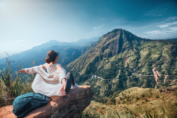 Fototapeta na wymiar Woman traveler enjoying early morning beautiful nature on background of mountain peak 