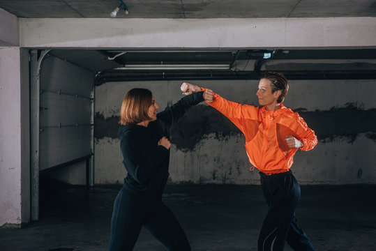 Two female athletes showing technical skills while practicing fighting in a garage