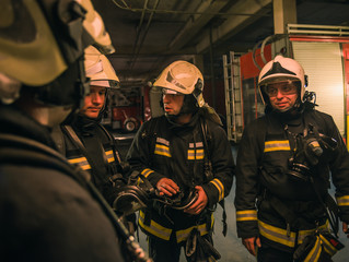 Fototapeta premium Group of firefighters with uniform inside the fire station preparing for safe rescue