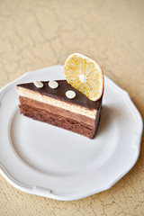 Chocolate sponge cake, with mousse, decorated with Orange slice and meringue. Breakfast in the cafe, morning coffee. on wooden table.