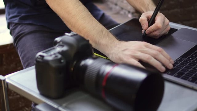 Close up of creative photographer using graphic tablet for retouching. Close up of hands. Slider shot.