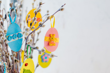 Easter eggs on willow branches on light background with copy space - Powered by Adobe