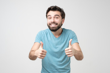 Fototapeta premium Happy hispanic man with thumbs up gesture