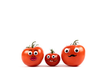 Three tomatoes with funny faces, a tomato woman, a tomato child and a tomato man, white background and copy space