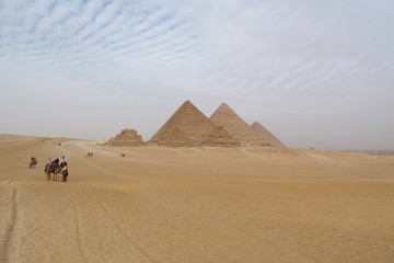 People on camels near Great Pyramids of Giza in Egypt