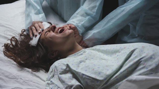 exhausted tired woman in labor gives birth to child, maternity ward pushing hard, young mother screams writhing in pain during childbirth in hospital, professional medical care of doctors, pregnancy