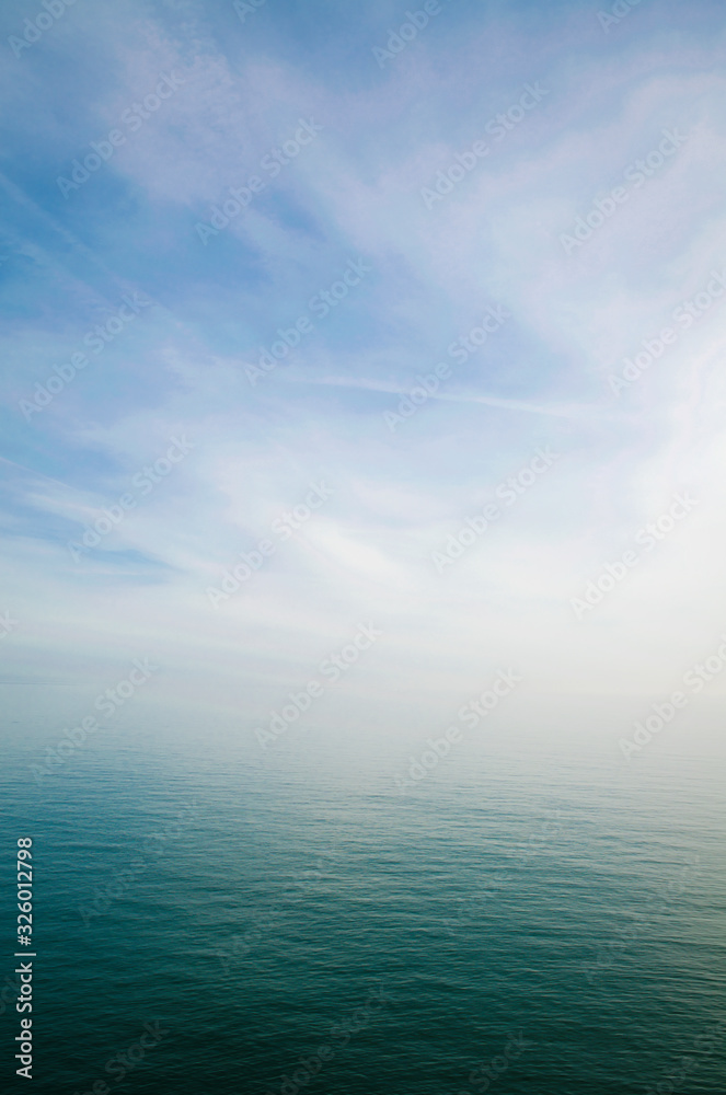 Wall mural scenic view of sky and sea blending into a misty white horizon