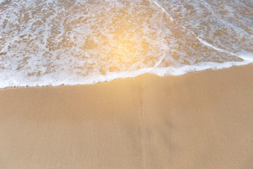 White wave on brown sand beach, vintage outdoor warm light, nature concept background