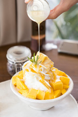 deligious mango bingsu pouring sweetened condensed milk