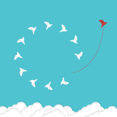Think differently concept. Be different. Red bird changing direction. New idea, change, trend, courage, creative solution, innovation and unique way concept.	