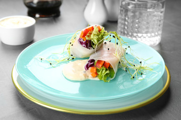 Delicious rolls wrapped in rice paper served on grey table