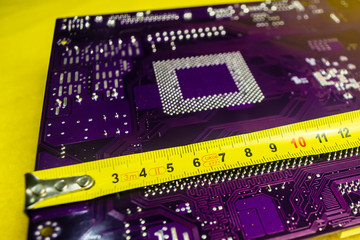 Centimeter Tape measures the motherboard. Blurred background
