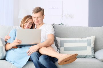Fototapeta premium Beautiful couple with laptop at home