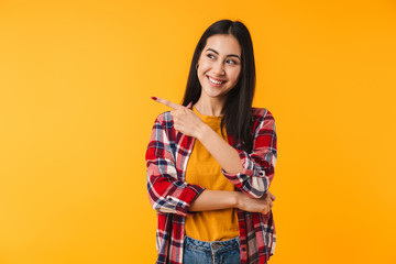 Image of happy attractive woman smiling and pointing finger aside