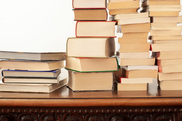 stack of piled books rest on a wooden table with copy space for your text