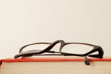 close up on a red book cover and eye glasses with copy space for your text