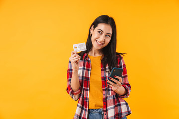 Image of happy attractive woman holding credit card and using cellphone