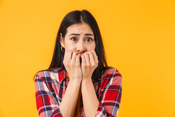 Image of scared woman covering her mouth and looking at camera
