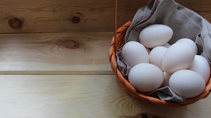turkey eggs in wicker basket on a light wooden table and copy space