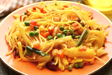 Plate with tasty pasta and vegetables on table, closeup