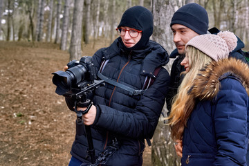 Photographer and a couple in late winter forest