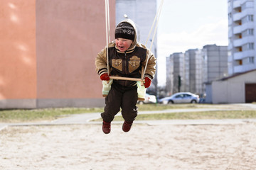 child on a swing in the playground in spring