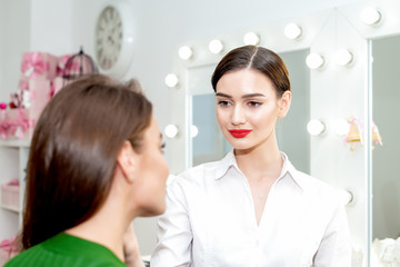 Make up artist doing professional make up of young woman, makeup artist ready to work on a client.