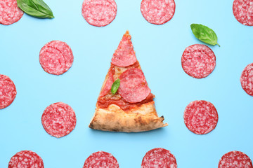 Slice of tasty pizza with sausages on color background