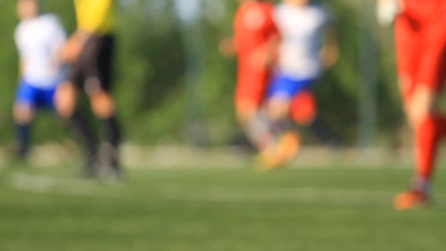 Legs of soccer players and referee in blur