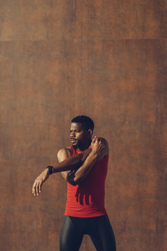 Young black man exercising against a wall