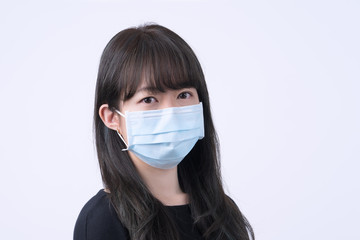 Young Asian woman portrait, wearing a medical surgical blue face mask for epidemic prevention, air pollution isolated on white background, copy space, close up, cut out