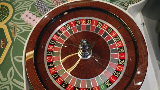 Сasino: roulette in Las Vegas with white ball.  The ball falls on the  field four black. Top view. Close-up. 4K video