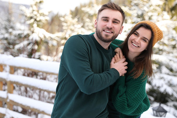 Lovely couple spending time together on snowy day. Winter vacation