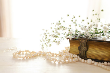 Vintage antique book and pearls necklace. Wedding concept. Back light