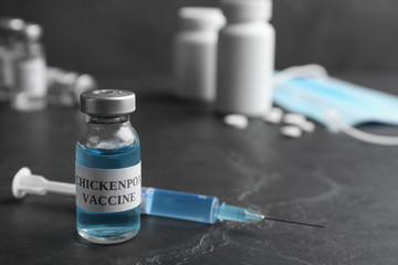 Chickenpox vaccine and syringe on grey background, space for text. Varicella virus prevention