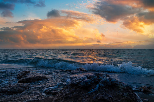 Beautiful landscape. Bright colorful sunset with dramatics clouds over the lake. 