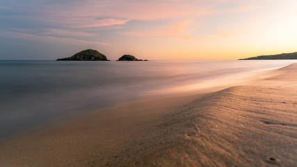 Long exposure of Su Giudeu beach at sunset, soft waves beach and sand