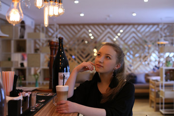 horizontal portrait of a beautiful blonde with long hair on the background of the interior of the bar