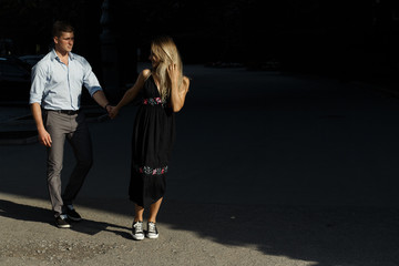 happy couple, man and woman, over black background. hold hands, go and smile