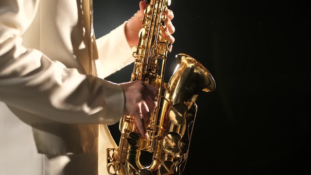 Fingers of hands on saxophone of musician player close up. Live classic music melody in play instrument perform of elegant talent artist people in spotlight. Art work on occupation famous concert show