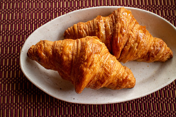 Two delicious croissants on a white plate 2　白い皿にのった美味しそうな二つのクロワッサン