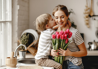 happy mother's day! child son gives flowers for  mother on holiday .