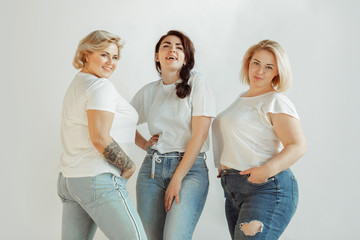 Confidence. Young caucasian women in casual clothes having fun together. Friends posing on white...