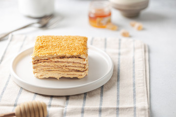 Delicious slice of homemade honey cake on white background.