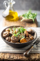 Baked champignons mushrooms with butter and roasted garlic in a bowl. Healthy food concept.