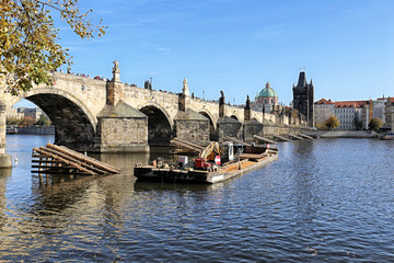 Fototapeta na wymiar Charles bridge in Prague with construction boat on sunny day