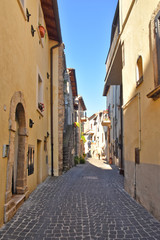 Fototapeta premium A narrow street between the old stone houses of a medieval village.