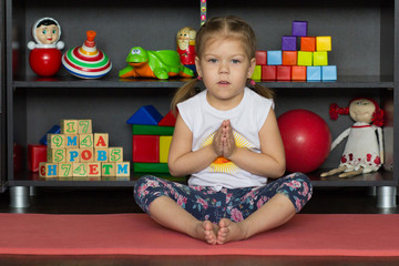Little girl making yoga pose of cobbler or butterfly as