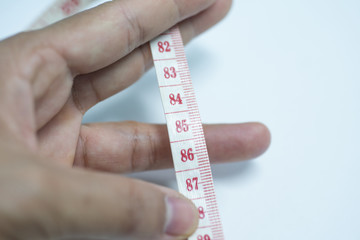 Tape measure in hand on white background.