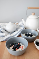 Tasty breakfast of Tvorog, farmers cheese, curd cheese or cottage cheese and blueberries in gray bowls. 
